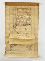 Stack of rolled county road maps fixed to backing board