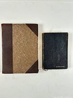 Front view of both books: larger brown leather-trim memoir and smaller black leatherette hymnary