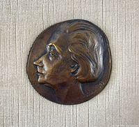 Close-up of bronze medal showing female profile relief