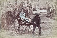Close view of hand-coloured photograph showing subject and rickshaw