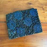 Front of carved wooden block showing floral relief pattern and blue pigment