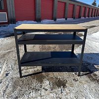 Front view of IKEA Bror utility bench showing plywood top and two black shelves