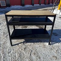 Front view of IKEA Bror bench showing wood top and two black shelves