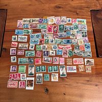 Full spread of assorted U.S. postage stamps on wooden surface