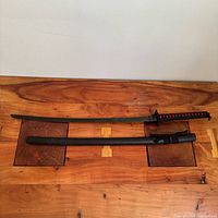Sword unsheathed and scabbard on wooden surface