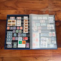 Open stockbook showing two filled pages of assorted Canadian stamps