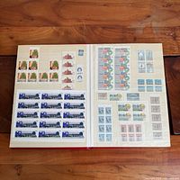 Album open showing multiple Canadian stamp sheets on two facing pages