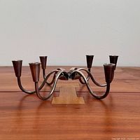 side view of six-arm chromed metal candelabra with brown candle cups