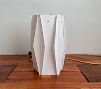 Front view of folded plastic pendant lamp with cord