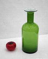 Vase standing upright beside red reference object showing color and form