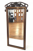 Full view of mirror angled showing frame and crest