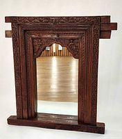 Front view of carved teak mirror showing full frame and mirror insert