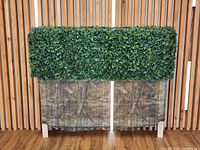 Front view of artificial hedge on stand