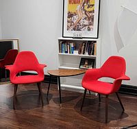 Both red Organic armchairs beside small table and bookcase