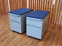 Front angled view of both cabinets showing drawers, handles, casters