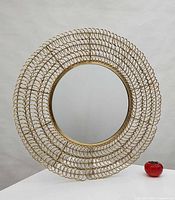 Front view of round mirror showing full gold wire loop frame and glass