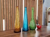 Front view of three colored glass genie bottles
