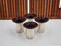 Four candle holders displayed upright