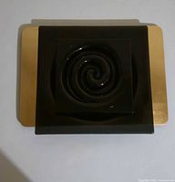 Stacked view showing black spiral tray atop gold tray