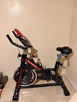Right side view showing full exercise bike with handlebars, seat, flywheel