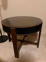 Full view of round wooden side table, glass top visible