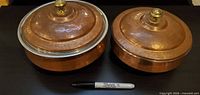 pair of covered hammered copper dishes, lids on for overall view
