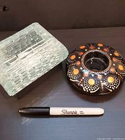 Top view of glass block holder, painted round holder, Sharpie for scale