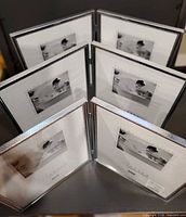 Six frame openings showing three hinged double frames standing upright, silver borders visible