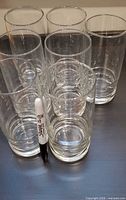 Front and side view of six of the seven clear tumblers with a Sharpie for scale
