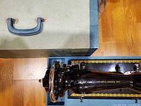 Top view of sewing machine partially inside blue case