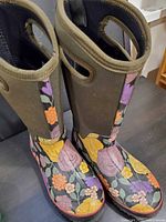 Full view of both boots showing floral pattern, shaft, handles