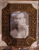 Front view showing ornate brass-tone filigree frame and 5" x 7" opening