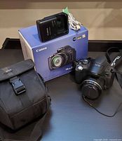 Camera, charger, box, bag displayed