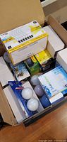 Open box showing multiple packages of LED, incandescent and halogen bulbs