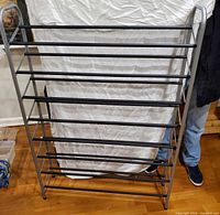 Front view of brushed metal shoe rack showing full height and width