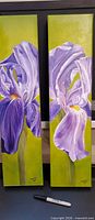 Front view of both signed iris oil paintings side by side with marker for scale