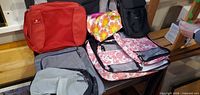Overview showing red Eagle Creek cube, grey cube, black bag, pink floral packing bags and multicolour cosmetic pouch