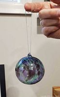 Full view of blown glass ornament held by string
