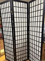 Full view of three-panel black wood shoji divider standing open