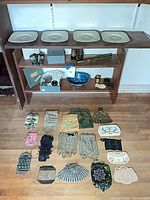 Full lot overview showing plates on shelf, telescope, binoculars, blue bowl, cloisonné pieces and spread of beaded purses