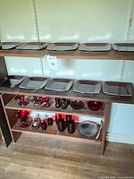 shelf with square plates and assorted red glass pieces