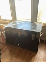 full view of black steamer trunk on floor