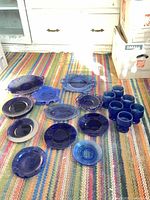 All cobalt blue glass pieces laid out on rug showing quantity and variety
