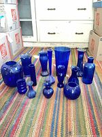 Group shot of all 15 cobalt blue glass vases