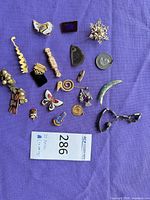 All twenty costume jewelry pieces laid out on purple cloth