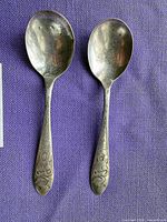 Two silver-plated Mickey Mouse teaspoons side by side