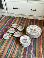 Overall lot view showing stacks of dinner plates, smaller plates and two-handled cups