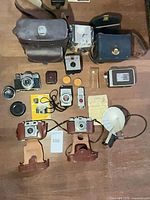Overall view of lot with cameras, light meter, flash, cases and accessories