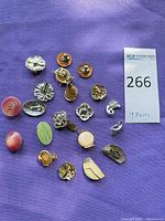 Full set of 19 clip-on earrings laid out on purple fabric