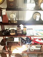 Shelf view showing stereoscope, cards, jar, tin match holder with lot tag